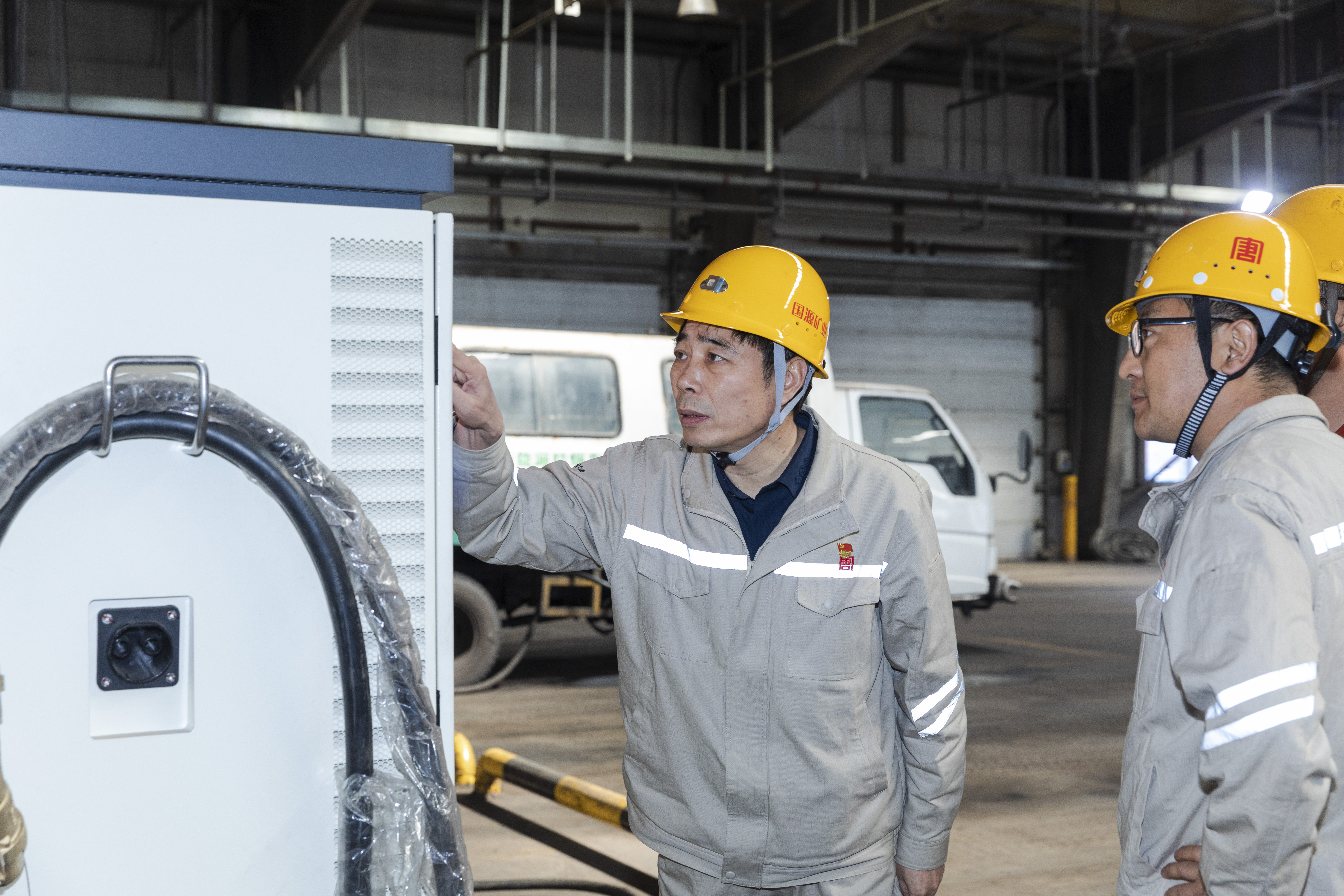 1729646592459010056.jpg 于进在龙王沟煤矿辅运工区检查新能源汽车充电装置清静运行情形.jpg